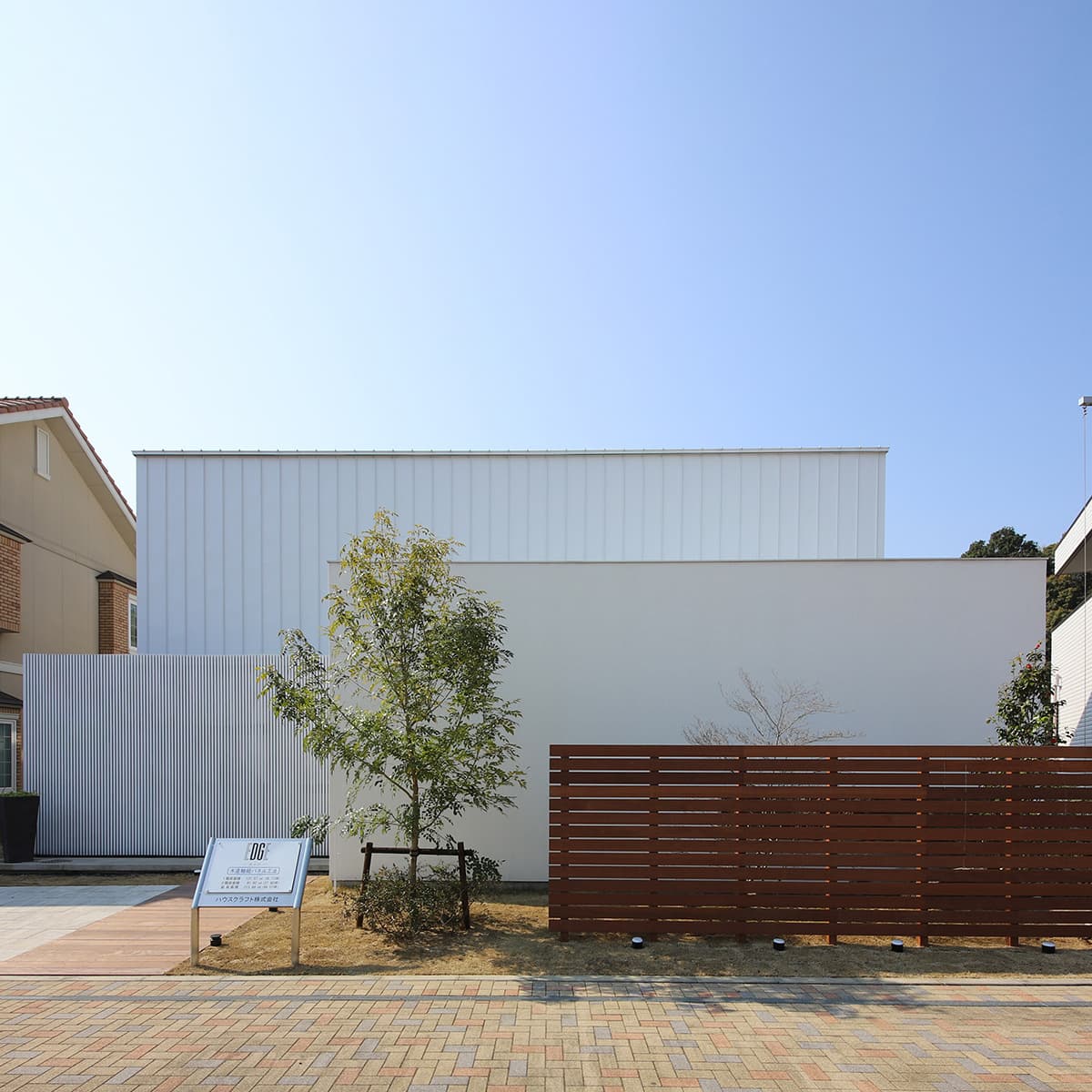 四角が重なる白い家とウッドフェンス